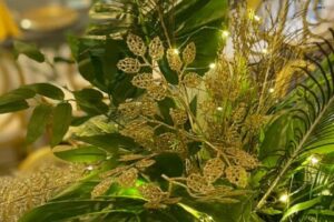 Dekoracje stołu przedstawiające liście monstery oraz pawie pióro